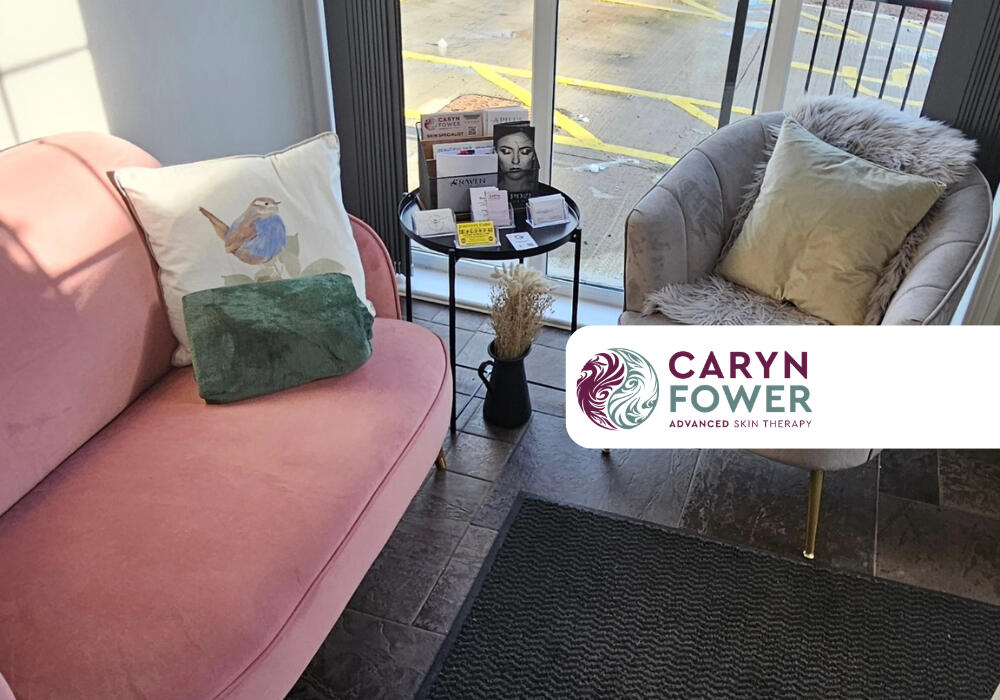 The Caryn Fower's Advanced Skin Therapy lobby with two arm charis and a small table in the middle with magazines on it. The Caryn Fower Advanced Skin Therapy logo is also featured in the bottom right corner of the photo.