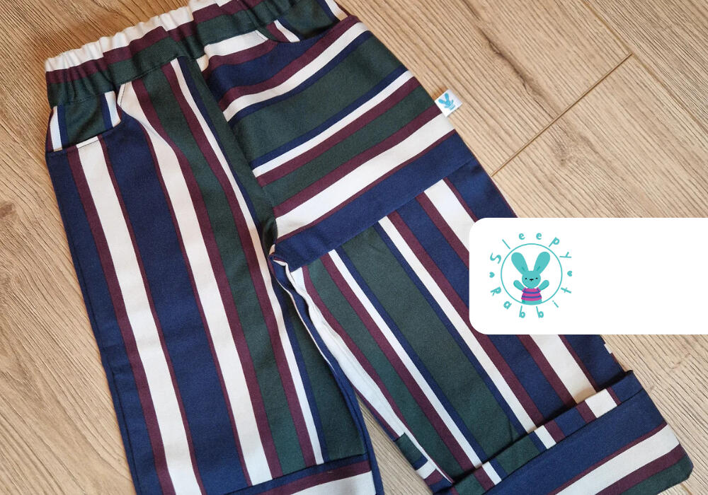 A pair of handmade stylish toddler trousers by Sleepy Rabbit. The Sleepy Rabbit logo is also featured in the top right corner of the photo.